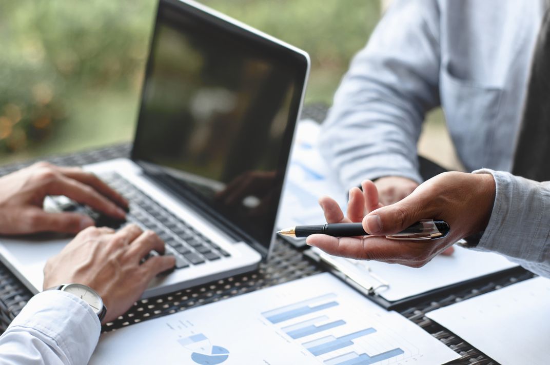 Business Executives discussing about sales performance at a modern outdoor workplace.